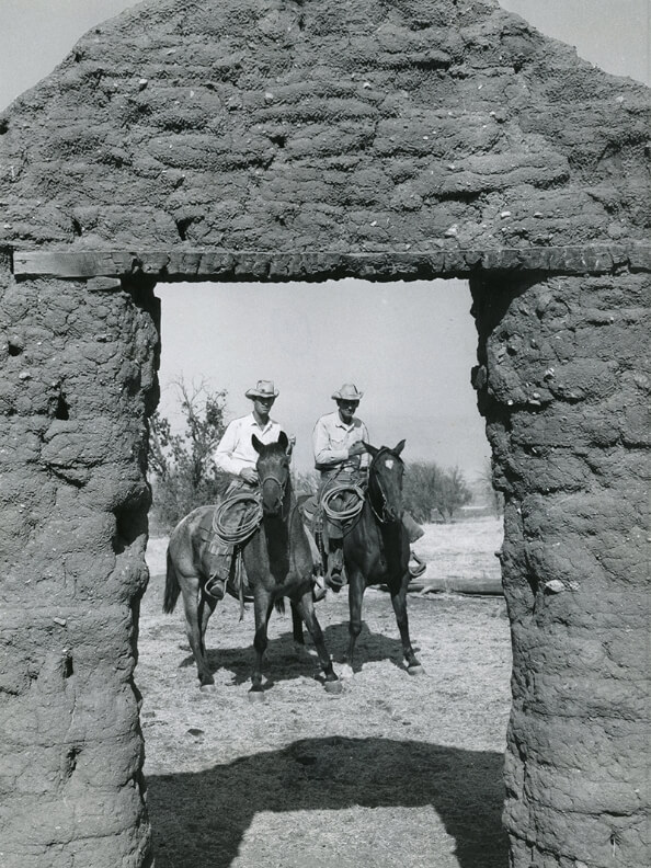 Historic photograph taken in the late 1800s of two early settlers of El Tejon on horseback wearing cowboy hats